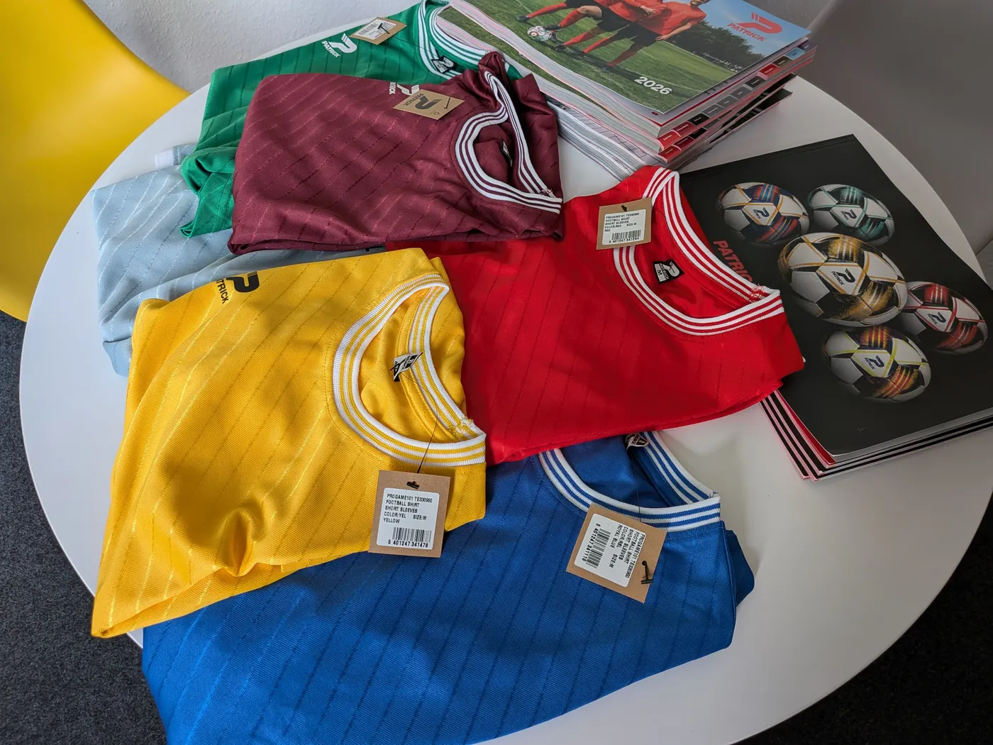 Patrick-Trikots in verschiedenen Farben auf dem Tisch im Showroom in Gladbeck